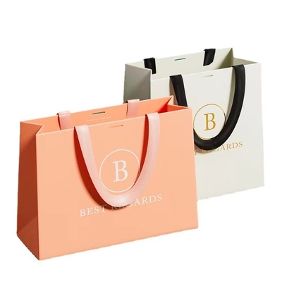 ODMのグレープフルーツ色のペーパー衣装袋の注文の印刷されたペーパー取得は袋に入れる