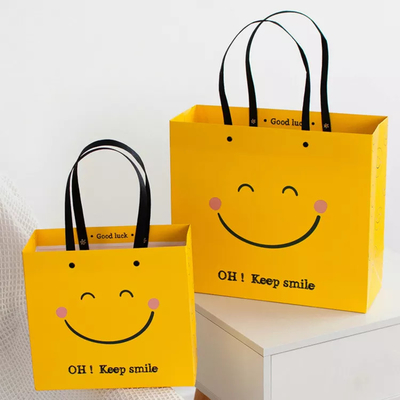 ISOの耐衝撃性の微笑の表面クラフトの紙袋の黄色い正方形の最下の紙袋